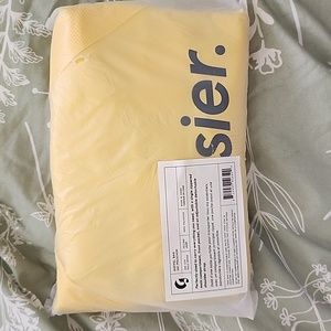Glossier yellow duffel bag